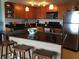 Kitchen island with seating, black countertops, and stainless appliances at 880 Mandalay Ave # N1004, Clearwater Beach, FL 33767