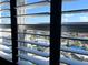 A window's view of the city and sky is partially visible through the white blinds at 880 Mandalay Ave # N1004, Clearwater Beach, FL 33767