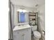 Bathroom featuring a white vanity, open shelving above toilet, and gray shower curtain at 880 S Village N Dr # 202, St Petersburg, FL 33716