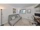 Carpeted bedroom featuring a futon, a window letting in natural light, and an adjacent desk area at 880 S Village N Dr # 202, St Petersburg, FL 33716