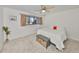 Cozy bedroom with neutral decor, ceiling fan, and window allowing natural light at 880 S Village N Dr # 202, St Petersburg, FL 33716