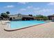 Community pool with a clear blue pool surrounded by brick patio and lounge chairs at 880 S Village N Dr # 202, St Petersburg, FL 33716