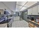 Well-lit kitchen features white cabinets, modern appliances, and tiled backsplash at 880 S Village N Dr # 202, St Petersburg, FL 33716