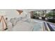 Bright living room featuring a plush gray couch, access to the balcony, and stylish decor at 880 S Village N Dr # 202, St Petersburg, FL 33716