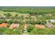 Sprawling aerial shot of a community featuring red tile roofs, lush landscaping, and a serene lake at 8907 Magnolia Chase Cirs, Tampa, FL 33647