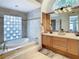 Bright bathroom with double vanities, soaking tub with tile surround, and glass block window at 8907 Magnolia Chase Cirs, Tampa, FL 33647
