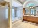 Bright bathroom with double vanities, soaking tub with tile surround, and glass shower at 8907 Magnolia Chase Cirs, Tampa, FL 33647