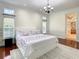Large bedroom with wood floors, a floral bedspread, and an ensuite bathroom at 8907 Magnolia Chase Cirs, Tampa, FL 33647