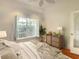 Relaxing bedroom features a ceiling fan, large window, and hardwood floors at 8907 Magnolia Chase Cirs, Tampa, FL 33647