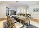 Open-concept dining room with a large wooden table and seating, offering a blend of rustic charm and elegance at 8907 Magnolia Chase Cirs, Tampa, FL 33647