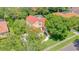 Exterior elevation of a two-story home featuring a red tile roof, and a well-manicured lawn with mature trees at 8907 Magnolia Chase Cirs, Tampa, FL 33647