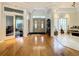 Bright foyer featuring wood floors, double doors, and a peek into a living area, conveying a welcoming and spacious entrance at 8907 Magnolia Chase Cirs, Tampa, FL 33647