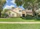 Inviting two-story home featuring a red tile roof, manicured lawn, and an arched entryway at 8907 Magnolia Chase Cirs, Tampa, FL 33647