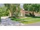 Charming home with a red tile roof, arched entryway, and manicured lawn with lush landscaping at 8907 Magnolia Chase Cirs, Tampa, FL 33647