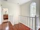 Hallway with hardwood floors leading to bathroom and a window at 8907 Magnolia Chase Cirs, Tampa, FL 33647