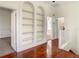 Spacious hallway featuring hardwood floors, built-in bookshelves, and natural light at 8907 Magnolia Chase Cirs, Tampa, FL 33647