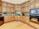 Gourmet kitchen featuring wood cabinetry, granite countertops, and modern stainless appliances at 8907 Magnolia Chase Cirs, Tampa, FL 33647