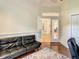 A stylish living room with hardwood floors, a black leather sofa, and decorative glass doors at 8907 Magnolia Chase Cirs, Tampa, FL 33647