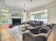 Cozy living room featuring a fireplace, plush sofas, and large windows offering abundant natural light and comfort at 8907 Magnolia Chase Cirs, Tampa, FL 33647