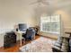 A bright home office with a large window, hardwood floors, and a ceiling fan at 8907 Magnolia Chase Cirs, Tampa, FL 33647