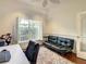 Bright office space with a black leather sofa, hardwood floors, and a large window with plantation shutters at 8907 Magnolia Chase Cirs, Tampa, FL 33647
