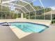 Screened-in pool with blue-tiled trim offers a refreshing and private outdoor oasis at 8907 Magnolia Chase Cirs, Tampa, FL 33647