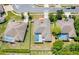 An aerial perspective of a residence featuring a screened pool, gray roof, and small backyard, located in a neighborhood at 1061 Archway Dr, Spring Hill, FL 34608