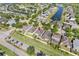 Aerial shot exhibits homes with backyard patios, landscaping, and neighborhood proximity to a scenic pond at 11207 Flora Springs Dr, Riverview, FL 33579