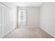 Bright bedroom with neutral carpet, closet, and window with white curtains at 11207 Flora Springs Dr, Riverview, FL 33579