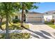 Charming home front view with a well-kept lawn and mature trees shading the facade at 11207 Flora Springs Dr, Riverview, FL 33579
