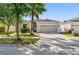 Charming single-story home with a well-manicured lawn, large driveway, and a two-car garage at 11207 Flora Springs Dr, Riverview, FL 33579
