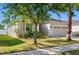 Attractive single-Gathering home featuring a manicured lawn, mature trees, and neutral exterior paint at 11207 Flora Springs Dr, Riverview, FL 33579
