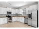 Modern kitchen features white cabinets, stainless steel appliances, granite counters and tile backsplash at 11207 Flora Springs Dr, Riverview, FL 33579
