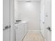 Functional laundry room equipped with a washer, dryer, and shelving at 11207 Flora Springs Dr, Riverview, FL 33579