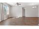 Open-concept living room with hardwood flooring, ceiling fan, and natural light at 11207 Flora Springs Dr, Riverview, FL 33579