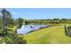 Scenic pond with an American flag, surrounded by green lawns and lush trees on a clear, sunny day at 11207 Flora Springs Dr, Riverview, FL 33579