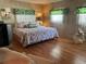 Comfortable bedroom with wood flooring, natural light and beach decor at 12501 Ulmerton Rd # 216, Largo, FL 33774