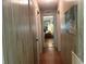 A hallway with wood flooring and decorative art leading to a bedroom at 12501 Ulmerton Rd # 216, Largo, FL 33774