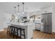 Modern kitchen with white cabinets, stainless steel appliances, and a large center island with bar stools at 12641 98Th St, Largo, FL 33773