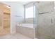Bright bathroom featuring a soaking tub with tiled surround and seamless glass shower at 13334 Palmera Vista Dr, Riverview, FL 33579