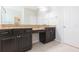 Bright bathroom with double granite vanities, dark cabinetry and large mirrors at 13334 Palmera Vista Dr, Riverview, FL 33579