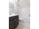 A well-lit bathroom features a shower-tub combo, dark vanity, and neutral tile floors at 13334 Palmera Vista Dr, Riverview, FL 33579
