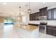 Open concept kitchen with stainless steel appliances, granite countertops, and views of the screened lanai at 13334 Palmera Vista Dr, Riverview, FL 33579