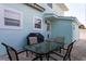 View of the patio with furniture, barbecue, white trimmed windows, and stucco wall of this two-story light blue home at 1411 Gray S St, Gulfport, FL 33707