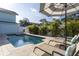 View of a private in-ground pool with lounge chairs, tropical landscaping and a white fence at 1411 Gray S St, Gulfport, FL 33707