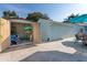 The backyard features an outdoor dining set and a shed loaded with pool toys and floats on shelving at 1411 Gray S St, Gulfport, FL 33707