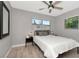Bedroom featuring a queen bed with a modern wooden headboard and two bedside tables with lamps and a ceiling fan at 1545 Illinois Rd, Clearwater, FL 33756