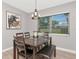 Well-lit dining room with a wooden table, comfortable seating, modern chandelier, and a view to the exterior at 1545 Illinois Rd, Clearwater, FL 33756
