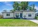 Charming single-story home featuring a well-manicured lawn and a freshly painted exterior with a bright blue front door at 1545 Illinois Rd, Clearwater, FL 33756