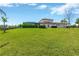 Large backyard with grassy lawn, screened in pool, and house exterior at 16419 Chapman Crossing Dr, Lithia, FL 33547